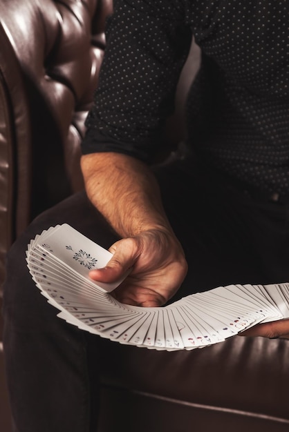 Closeup mãos inteligentes de mágico com cartões de jogo