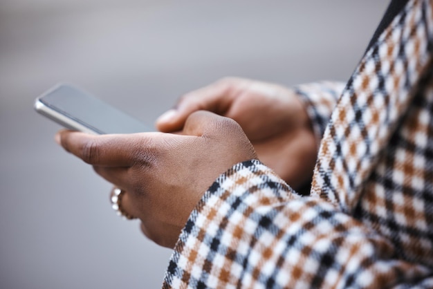 Closeup mãos negras e smartphone para digitar ao ar livre e conexão para bate-papo em mídia social e leitura on-line Mulher africana zoom e mulher com cidade de celular e comunicação com dispositivo