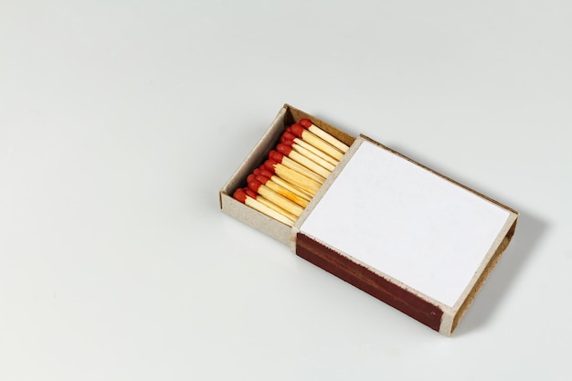 Foto closeup matchbox com fósforos vermelhos no local de foco seletivo de fundo branco para o dia internacional do jogo de texto