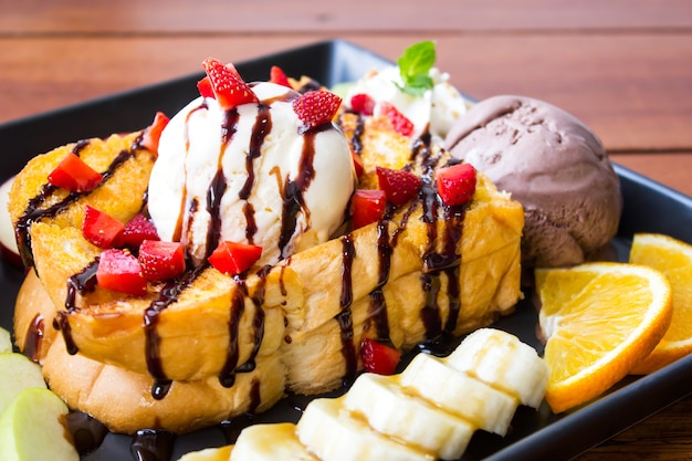 Foto closeup miel tostada. postre dulce servido con fruta variada y helado.