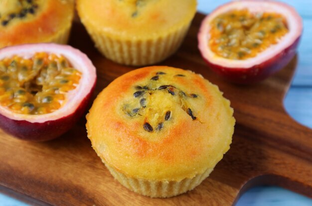 Closeup muffin de maracujá caseiro com frutas maduras cortadas na tábua de pão de madeira