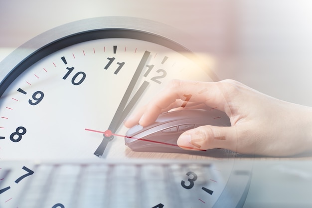 Closeup mujer de negocios trabajando con superposición de computadora portátil con reloj de horas de almuerzo de descanso de la tarde para concepto de horas de trabajo de oficina