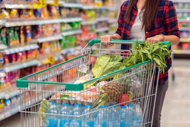 Closeup mujeres asiáticas jóvenes mano sosteniendo la carretilla para ir de compras