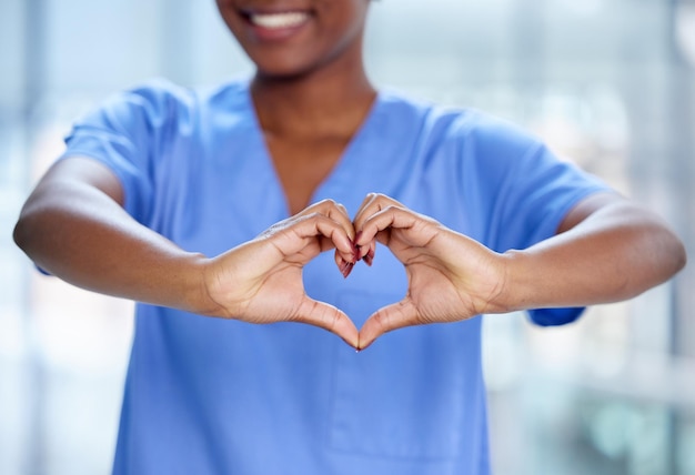 Foto closeup mulher negra e médica com mãos de coração apoiam e cuidam com felicidade, caridade e inovação profissional médica e funcionária do sexo feminino com símbolo de amor, solidariedade e feedback