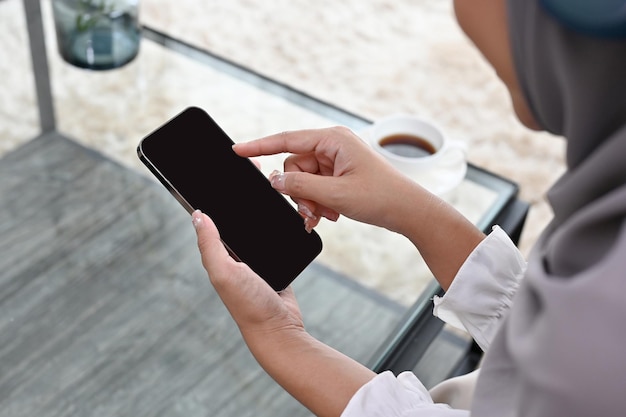 Closeup muslimische Frau mit einem Smartphone im Wohnzimmer