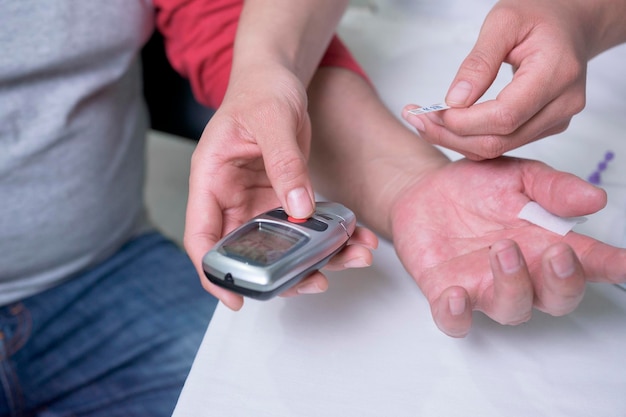 Closeup nas mãos de uma médica latina fazendo um teste para medir os níveis de açúcar