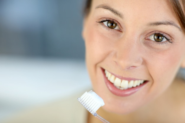 Closeup no sorriso de mulher escovando os dentes