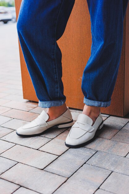 Closeup piernas femeninas en zapatos blancos de otoño Zapatos de mujer hechos de cuero genuino