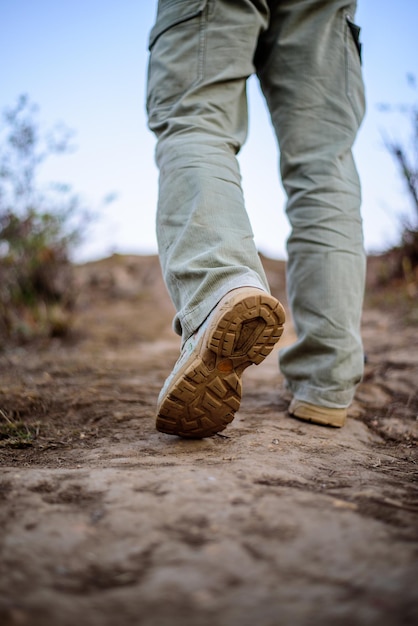 Closeup pies Hiker hombre con botas para viajar caminando en un bosque verde Viajes vacaciones y concepto de senderismo