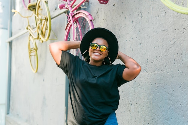 Closeup Portrait stilvolles junges afroamerikanisches Mädchen mit lockigem Haar in modischer Sonnenbrille in urban mit Kopierraum und Platz für Werbung für Sommer-Hipster-Fotos mit Instagram-Stil