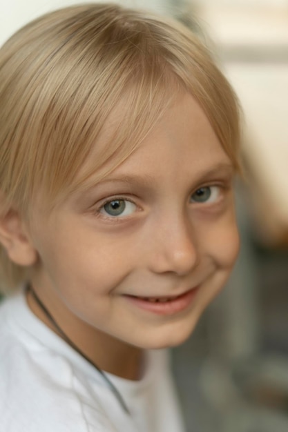 Closeup Portrait von blonden Jungen mit blauen Augen in die Kamera schauen Fairhaired Kind lächelnd