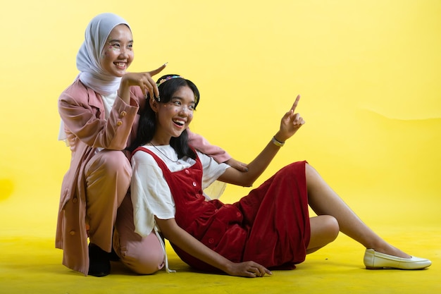 Closeup Portrait von zwei jungen schönen Asiatin isoliert auf gelbem Hintergrund.