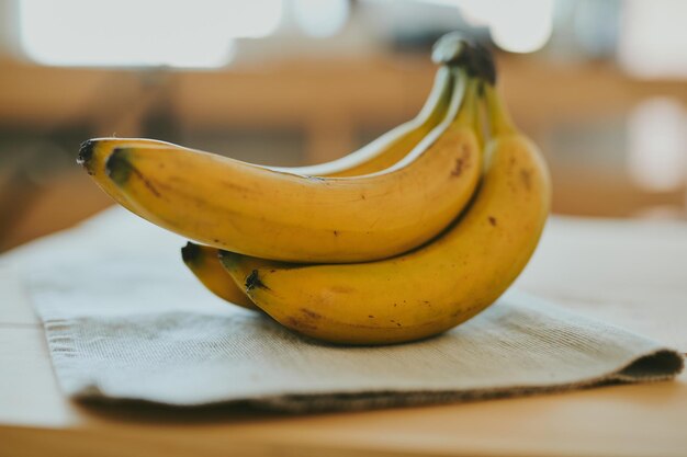 Closeup de un ramo de plátanos en un fondo de mesa de cocina de madera