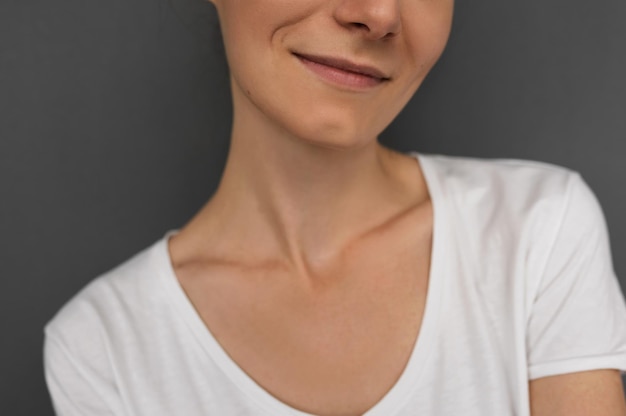 Foto closeup recortado retrato horizontal de atraente e sorridente feliz morena caucasiana vestindo camiseta casual com sorriso alegre e alegre em fundo cinza no estúdio