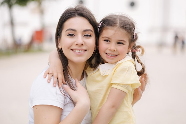 Closeup retrato de adorable hija con hermosa mamá feliz smiler hembras