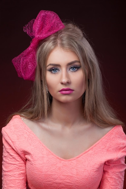 Closeup retrato aislado modelo rubia con lazo rosa