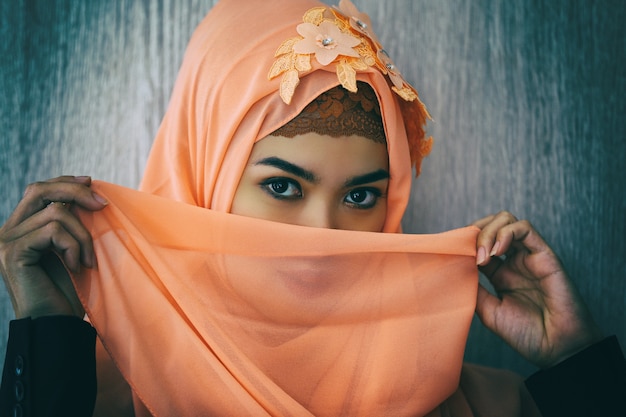 Closeup retrato de alegre dama musulmana en elegante pañuelo mirando a la cámara
