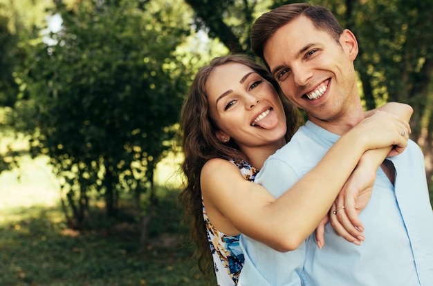 Foto closeup retrato ao ar livre de casal romântico apaixonado namoro ao ar livre no parque em um dia ensolarado casal feliz abraçando um ao outro e fazendo careta dia dos namorados