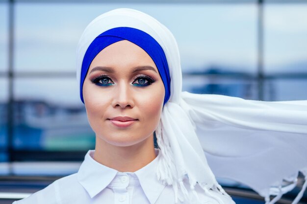 Closeup retrato atractiva y misteriosa mujer europea musulmana piel perfecta y encantador maquillaje de ojos la cabeza está cubierta con un pañuelo usando Hijab