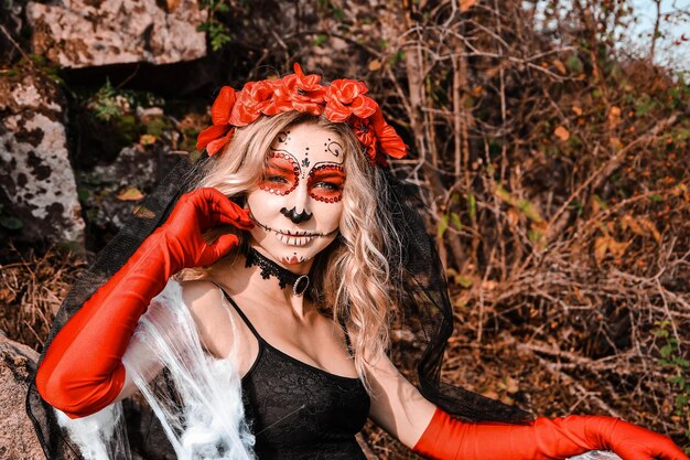 Closeup retrato de Calavera Catrina. Mujer joven con maquillaje de calaveras de azúcar y telaraña blanca. Día de los muertos. Dia de los Muertos. Víspera de Todos los Santos. Mujer maquillada Santa Muerte en la víspera de Halloween