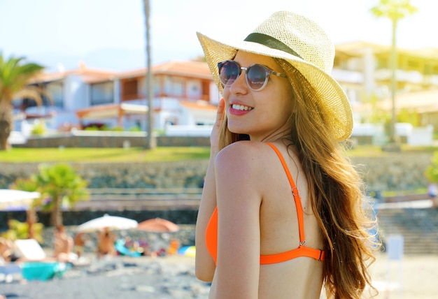 Closeup retrato de chica atractiva con cabello largo posando en la playa