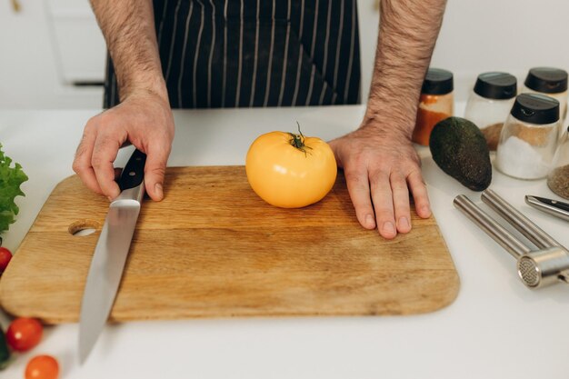 Closeup retrato de un cuchillo de cocina con un tomate amarillo