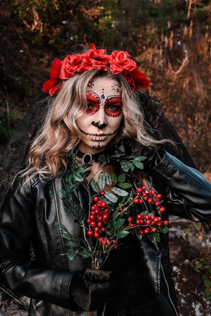 Closeup retrato de Calavera Catrina. Jovem mulher com maquiagem de caveira de açúcar e flores vermelhas. Dia de los muertos. Dia dos Mortos. Dia das Bruxas. Mulher de maquiagem Santa Muerte na véspera de Halloween. Criativo de moda