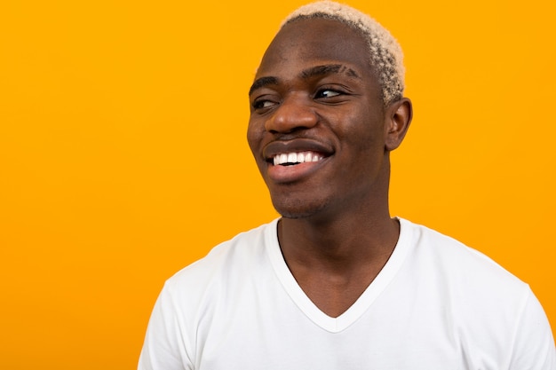 Closeup retrato de um homem africano loiro preto bonito sorridente na laranja