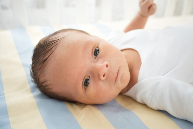 Closeup retrato de um lindo bebê recém-nascido deitado na cama