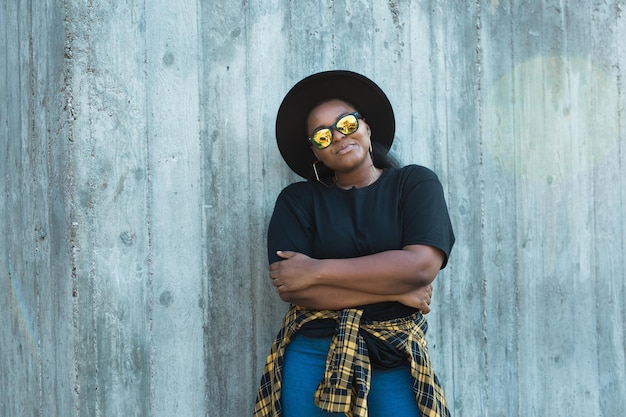 Closeup retrato elegante joven afroamericana con cabello rizado en gafas de sol de moda en urbano con espacio de copia y lugar para publicidad fotos hipster de verano con estilo instagram