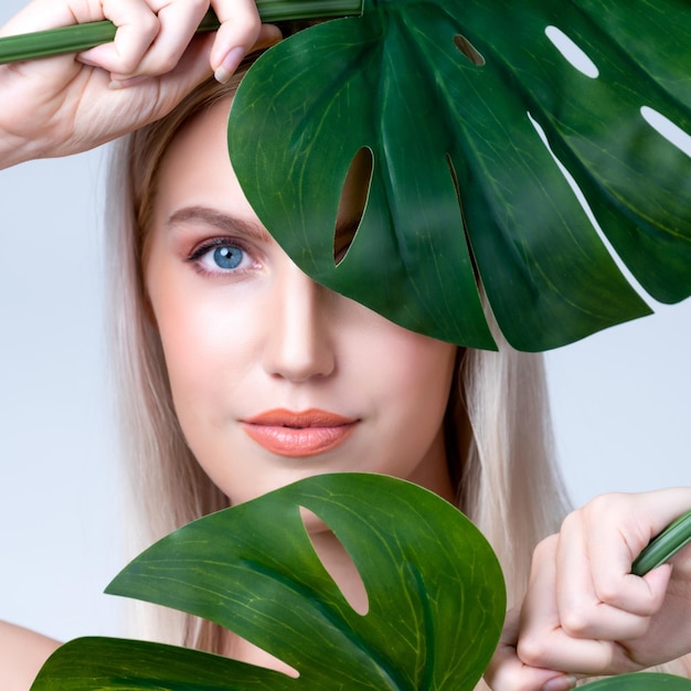 Closeup retrato facial mulher apresentável segurando monstera verde