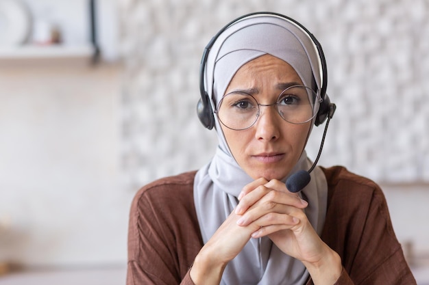 Closeup retrato fotográfico de uma jovem árabe em hijab e fone de ouvido, ele olha seriamente para a câmera