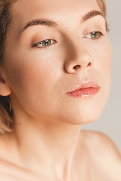 Closeup retrato de una hermosa chica caucásica con ojos verdes, maquillaje desnudo, piel perfecta, tiro del estudio. El concepto de belleza natural.