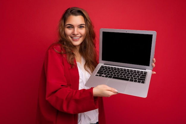 Closeup retrato de hermosa mujer morena joven feliz sonriente sosteniendo ordenador portátil