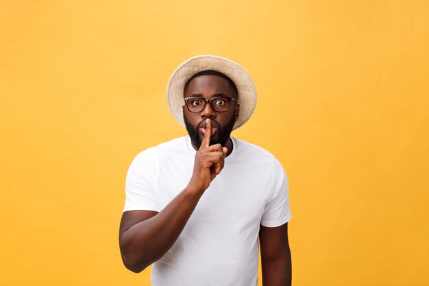 Closeup retrato de hombre negro colocando el dedo en los labios