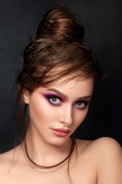 Closeup retrato de joven bella mujer con maquillaje de verano moderno de ojos ahumados rosa brillante