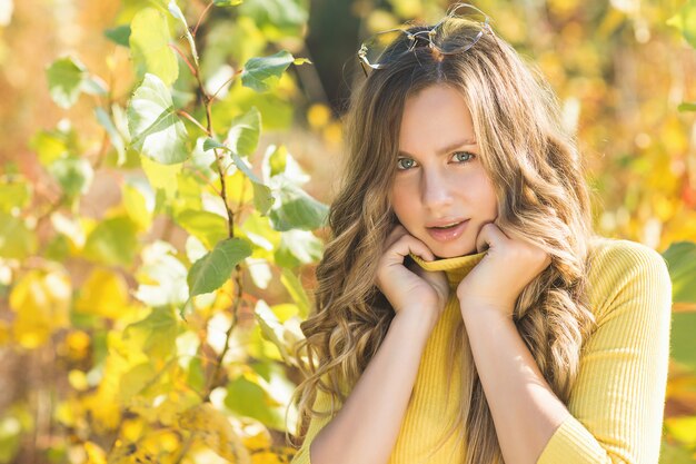 Closeup retrato de joven bella mujer en otoño. Elegante mujer atractiva en otoño. Mujer rubia con pelo rizado.