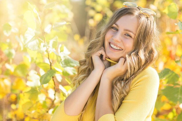 Closeup retrato de joven bella mujer en otoño. Elegante mujer atractiva en otoño. Mujer rubia con pelo rizado.