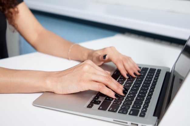 Closeup retrato de manos de mujer escribiendo en la computadora portátil