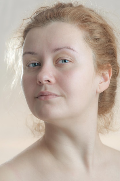 Closeup retrato de una mujer adulta joven atractiva con pelo rojo sin maquillaje. Tonificación de arte. Enfoque suave. Fondo neutro.