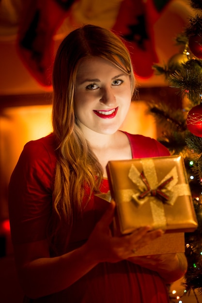 Closeup retrato de mujer feliz con caja de regalo de Navidad brillante