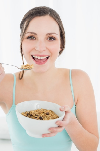 Closeup retrato de una mujer joven con un tazón de cereal