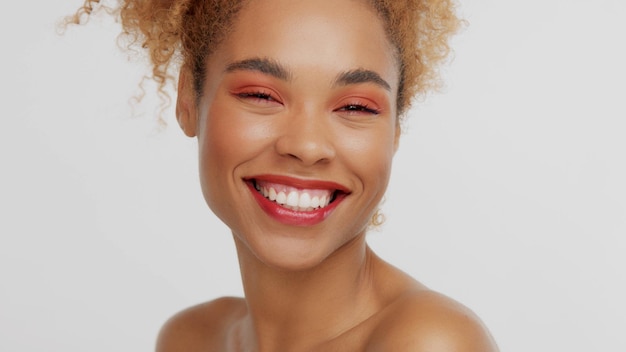 Closeup retrato de mujer mixta rase con maquillaje rojo en estudio feliz riendo sonriendo