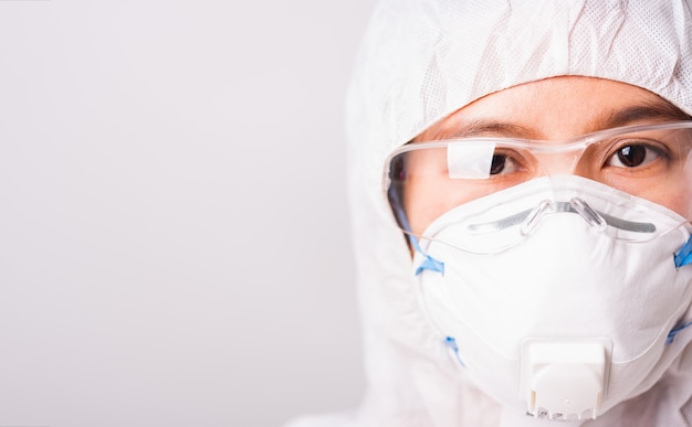 Closeup rostro de mujer médico en PPE suite uniforme con mascarilla N95 protectora y anteojos en laboratorio