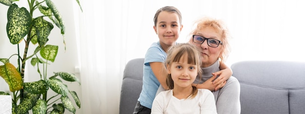 Closeup Sommerporträt der glücklichen Großmutter mit Enkelkindern im Freien zu Hause.