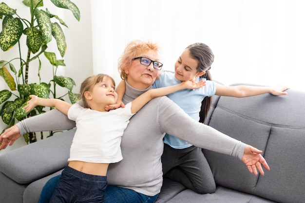 Closeup Sommerporträt der glücklichen Großmutter mit Enkelkindern im Freien zu Hause.