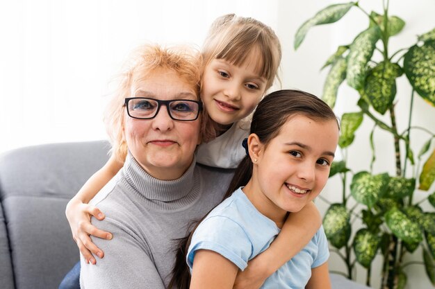 Closeup Sommerporträt der glücklichen Großmutter mit Enkelkindern im Freien zu Hause.