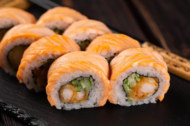 Closeup Sushi roll filadélfia com caranguejo e pepino e caviar de cream cheese em fundo preto closeup Sushi menu conceito de comida japonesa
