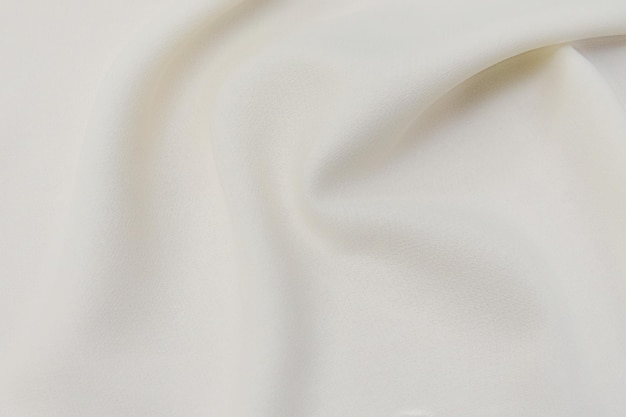 Closeup textura de tecido natural bege ou marfim ou pano na cor marrom Textura de tecido de algodão natural ou material têxtil de linho Fundo de tela bege