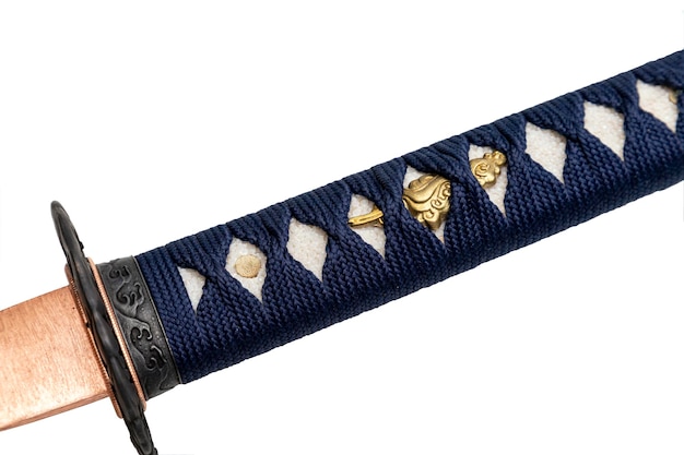 Closeup Tsuka mango de espada japonesa envuelto por cordón de seda azul marino con ajuste de oro aislado en fondo blanco Enfoque selectivo